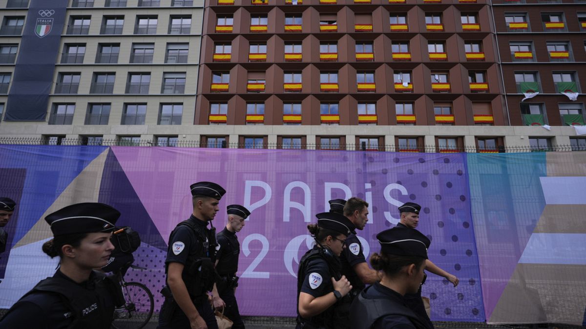 Police walk outside the perimeter of the Olympic Village, past housing for the Spanish, Italian and Moroccan teams, at the 2024 Summer Olympics, July 23, 2024, in Paris