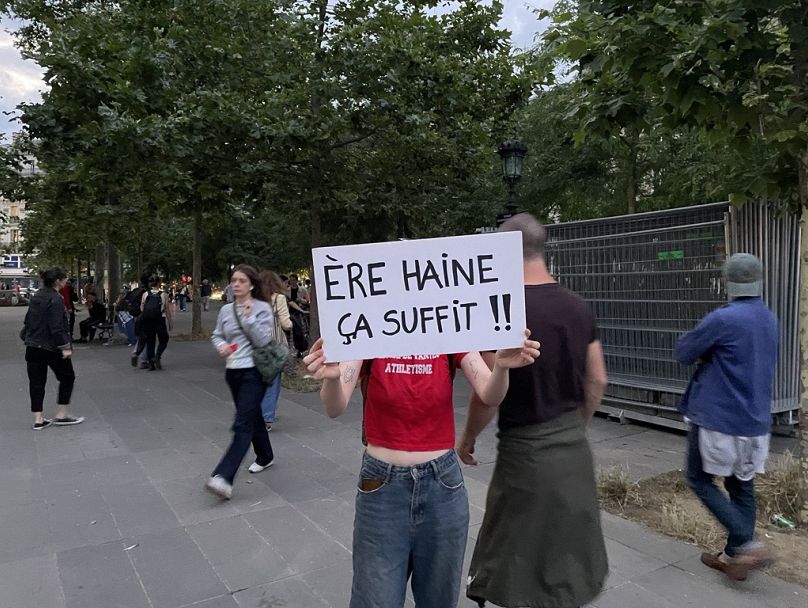 Un manifestant avec une pancarte qui joue sur le nom du parti d'extrême droite, le RN, pour dire "L'ère de la haine, ça suffit".