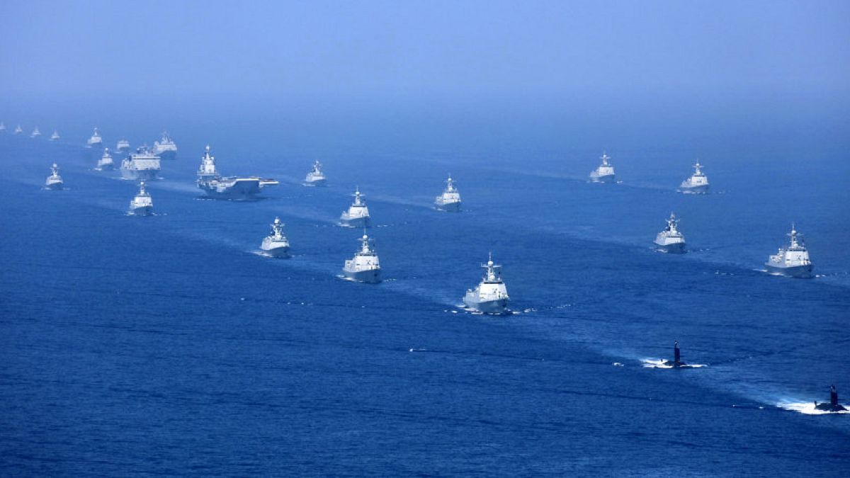 In this April 12, 2018 photo released by Xinhua News Agency, the Liaoning aircraft carrier is accompanied by navy frigates and submarines conducting an exercises in the South