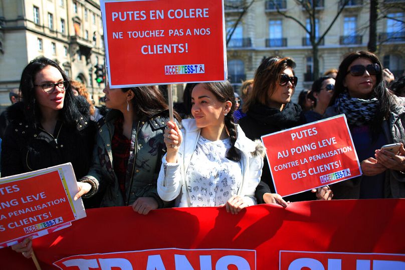 Des travailleuses du sexe brandissent des pancartes sur lesquelles on peut lire « Les prostituées sont en colère. Ne touchez pas à nos clients » lors d'une manifestation contre le nouveau projet de loi contre la prostitution et le trafic sexuel, à Paris, mercredi.