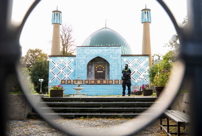 Un policier se tient devant le centre islamique de Hambourg avec la mosquée Imam Ali lors d'un raid le mercredi 24 juillet 2024, à Hambourg, en Allemagne. 