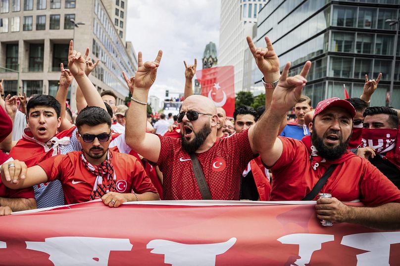 Les supporters turcs montrent le « salut du loup », dont l'origine est attribuée à un mouvement d'extrême droite, lors d'une marche des supporters avant le début du quart de finale de l'Euro 2024 