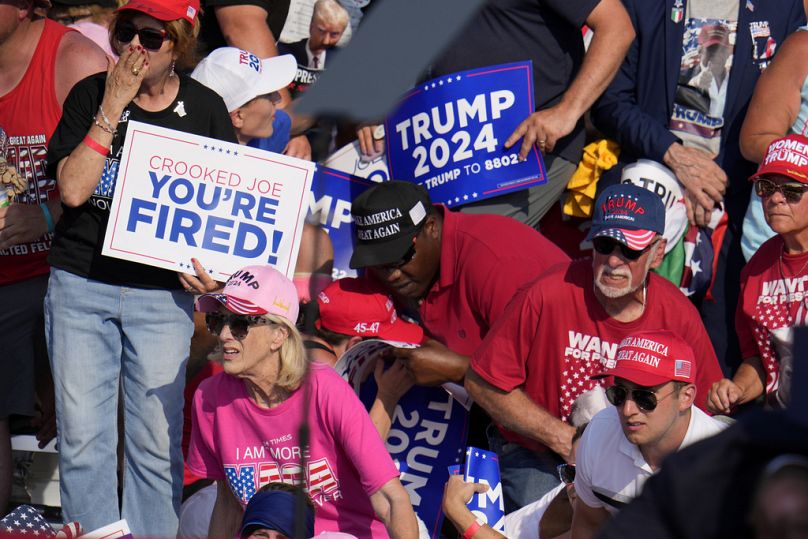 Des membres de la foule réagissent alors que des agents des services secrets américains encerclent Donald Trump lors d'un événement de campagne à Butler, en Pennsylvanie, le samedi 13 juillet 2024.