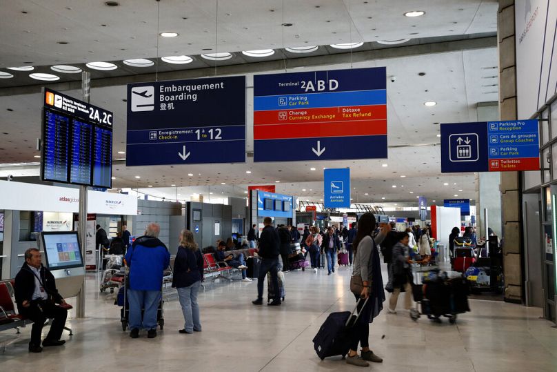 Des passagers attendent dans le hall des arrivées de l'aéroport Paris Charles de Gaulle, à Roissy, près de Paris - les futurs voyageurs pourraient-ils être confrontés à des perturbations ?