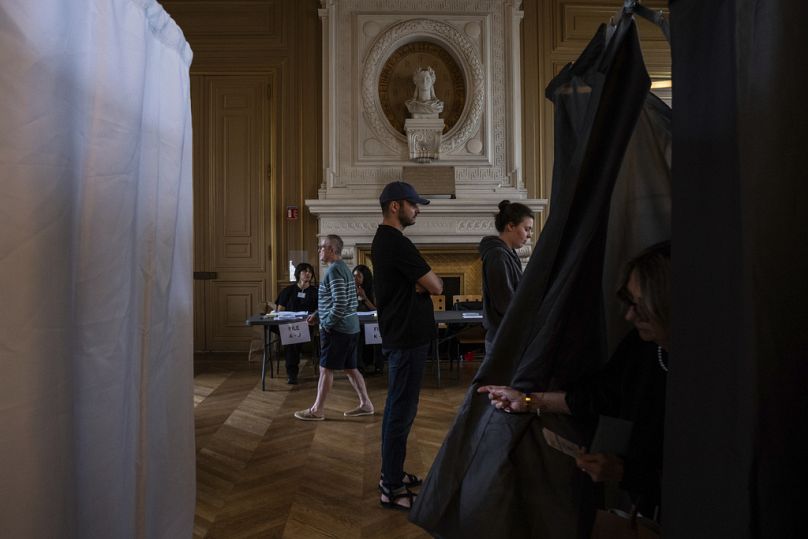 Des électeurs font la queue pour voter lors du second tour des élections législatives, dimanche 7 juillet 2024 à Paris.