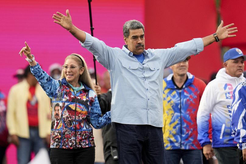 Le président Nicolas Maduro ouvre les bras aux côtés de la première dame Cilia Flores lors de son rassemblement de clôture de campagne électorale à Caracas, au Venezuela, le jeudi 25 juillet 2024.