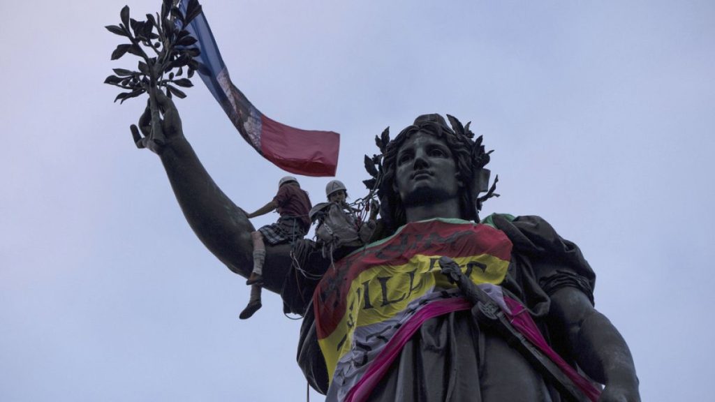 Statue of Republique plaza is decorated by flags as people gather at a protest against the far-right, Wednesday, July 3, 2024 in Paris.