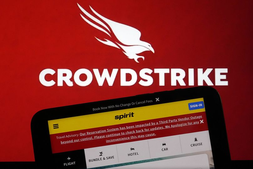 Le logo de CrowdStrike et une page Web de Spirit Airlines sont affichés sur un écran d'ordinateur et un écran de téléphone portable à New York, le 19 juillet 2024