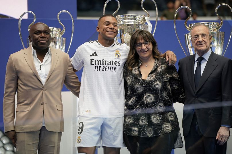 Kylian Mbappé, de France, pose avec ses parents et le président du Real Madrid Florentino Perez, à droite, après avoir été présenté aux fans comme nouveau joueur du Real Madrid.