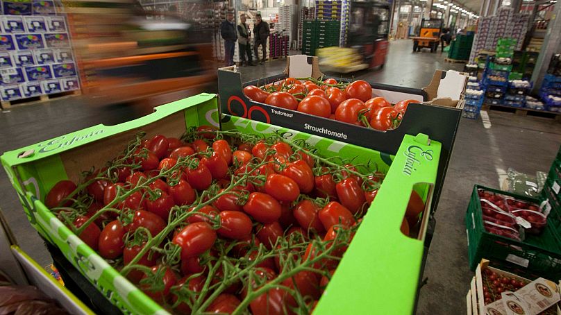 Les chariots élévateurs circulent entre les palettes de légumes et de fruits des grossistes pendant les heures d'ouverture du marché central de Berlin.