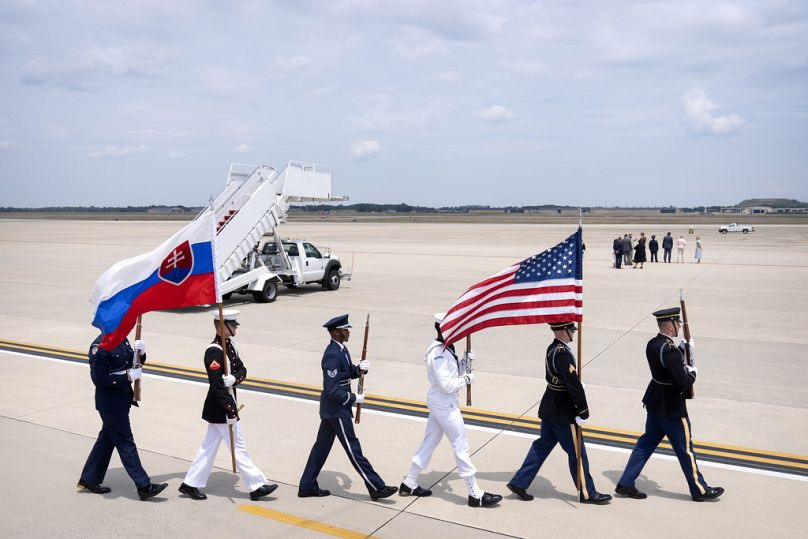 Une garde d'honneur porte des drapeaux américains et slovaques alors qu'elle défile sur le tarmac avant l'arrivée du président slovaque Peter Pellegrini, le 8 juillet 2024