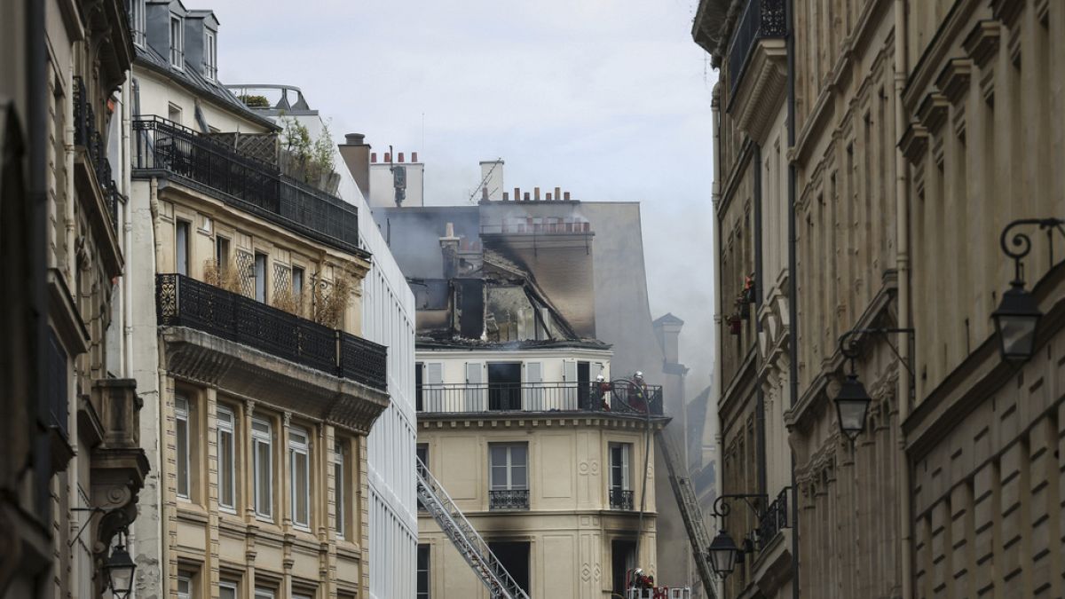 Firefighters work in a tiny street after a fire has broken out in an apartment building, Saturday, July 20, 2024, in the center of Paris, France. (AP Photo/Thomas Padilla)