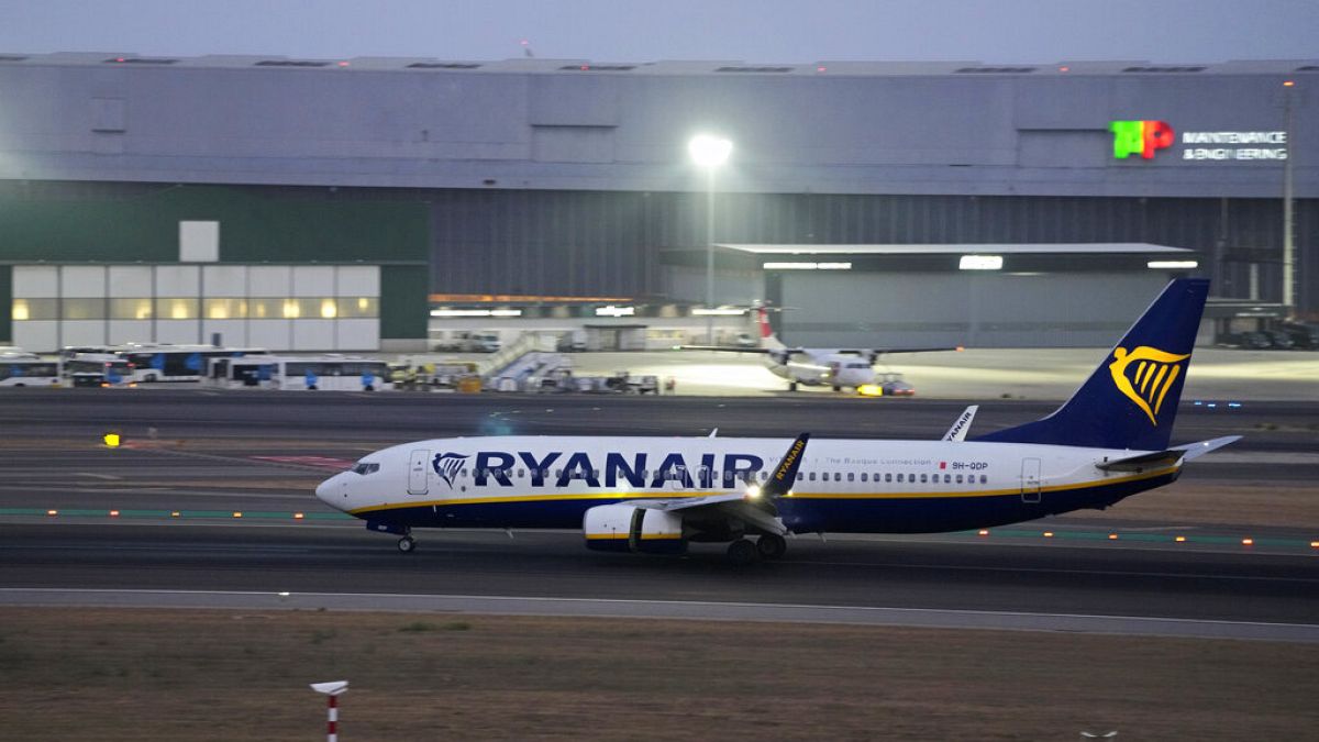 A Ryanair Boeing 737 lands at Lisbon airport, as night falls Friday, Aug. 26, 2022. (AP Photo/Armando Franca)