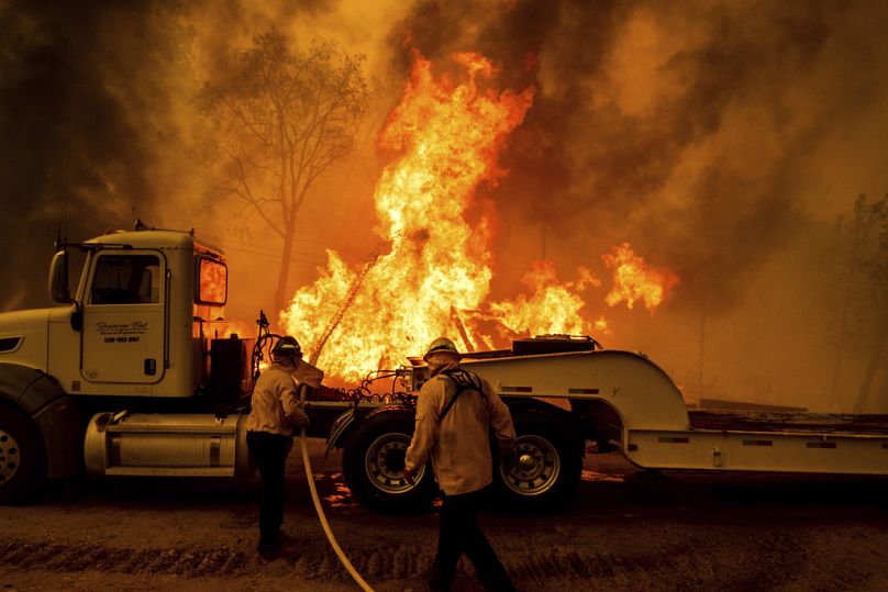 Les pompiers pulvérisent de l'eau alors que l'incendie du parc ravage la communauté de Cohasset dans le comté de Butte.