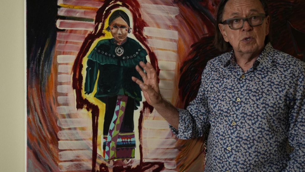 Joe Baker, a member of the Delaware Tribe of Indians and co-founder of the Lenape Center stands next to a painting of an Ohtas during an interview in his home in New York.