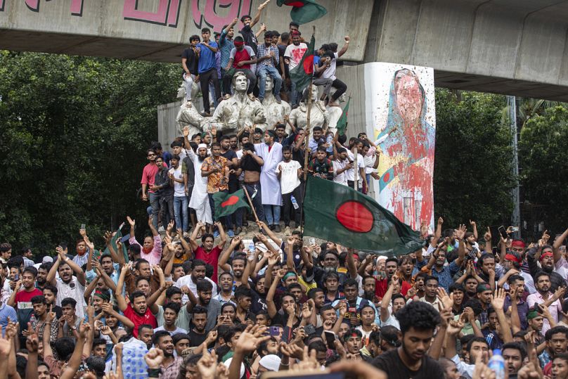 Des manifestants escaladent un monument public alors qu'ils célèbrent la nouvelle de la démission du Premier ministre Sheikh Hasina, à Dhaka, au Bangladesh, le lundi 5 août 2024.