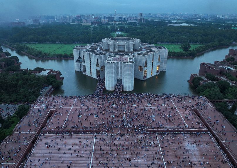 Des manifestants célèbrent dans les locaux du Parlement après l'annonce de la démission du Premier ministre Sheikh Hasina, à Dhaka, au Bangladesh, le lundi 5 août 2024.