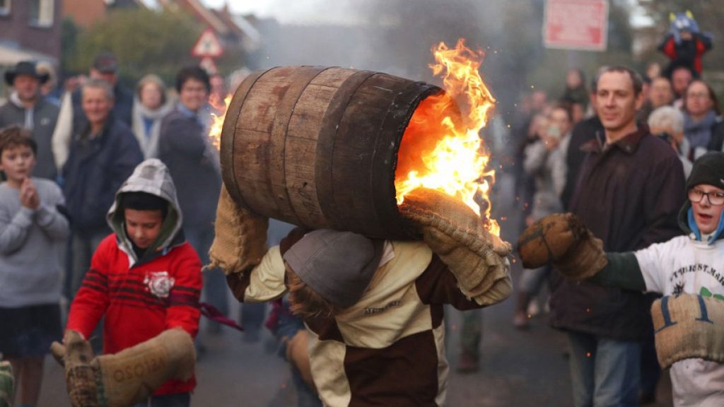 People from the Devonshire village of Ottery St Mary, southwest England, carry a traditional tar barrel through the streets of the village.