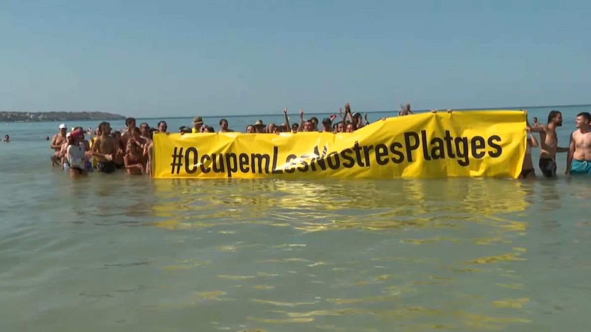 Protesters take to the Baleario 6 beach in demonstration of the effects of mass tourism.