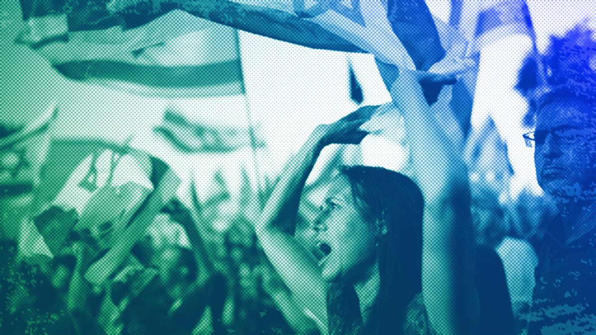 People wave Israeli flags during a protest against Israeli PM Benjamin Netanyahu