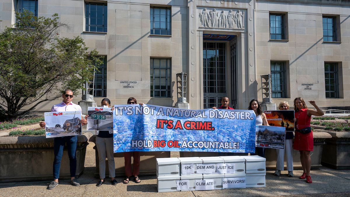 Activists deliver a letter with more than 10,000 signatures from climate survivors and their allies to the Department of Justice on Thursday