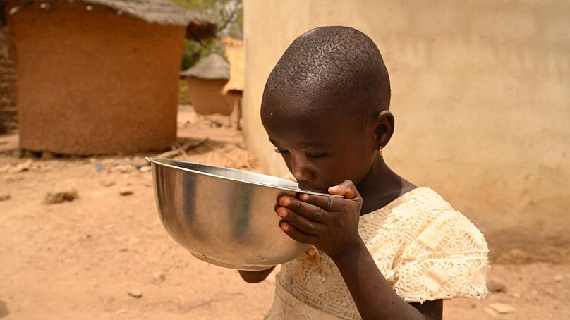 Un enfant boit de l'eau dans le village de Nambekaha, au nord de la Côte d'Ivoire