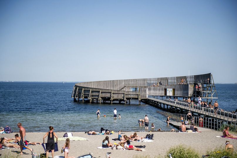 Les gens se baignent dans la mer et s'assoient sur la plage de la station balnéaire de Kastrup à Copenhague, au Danemark, le vendredi 1er juin 2018. 