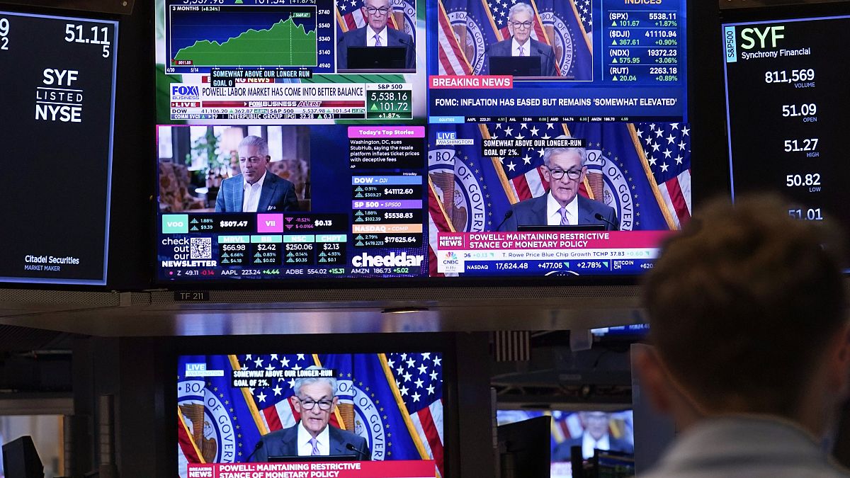 A bank of television screens on the floor of the New York Stock Exchange shows Federal Reserve Chairman Jerome Powell, July 31, 2024