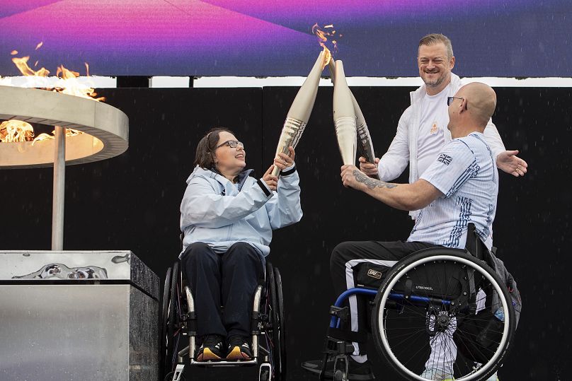 Les paralympiens britanniques Helene Raynsford et Gregor Ewan allument la flamme paralympique à Stoke Mandeville, berceau des Jeux Paralympiques, le samedi 24 août 2024.