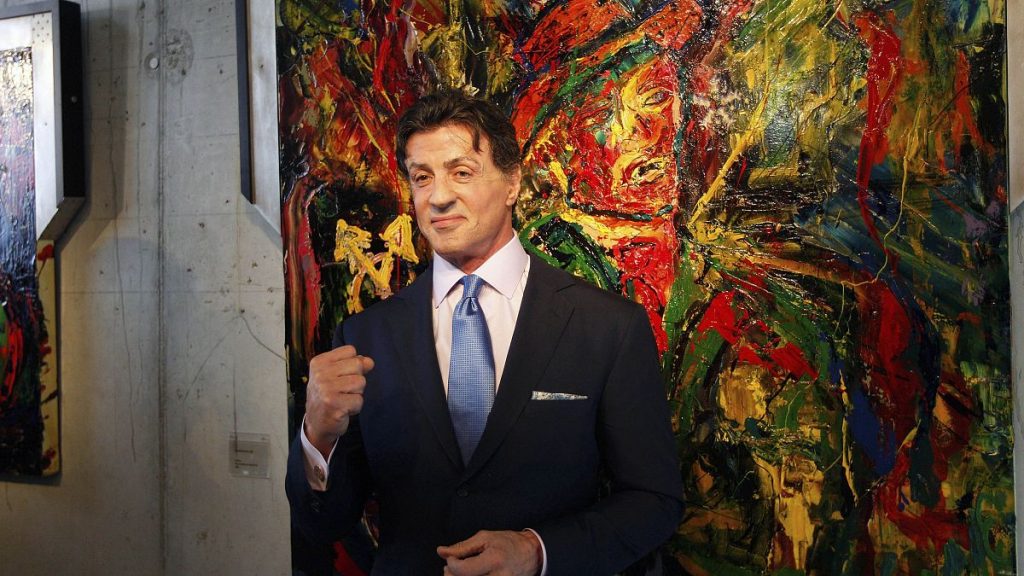 US Actor Sylvester Stallone, poses in front of one of his works during a press conference ahead of the exhibition