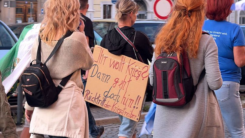 Un manifestant à Görlitz lundi porte une pancarte sur laquelle on peut lire (en allemand) : 