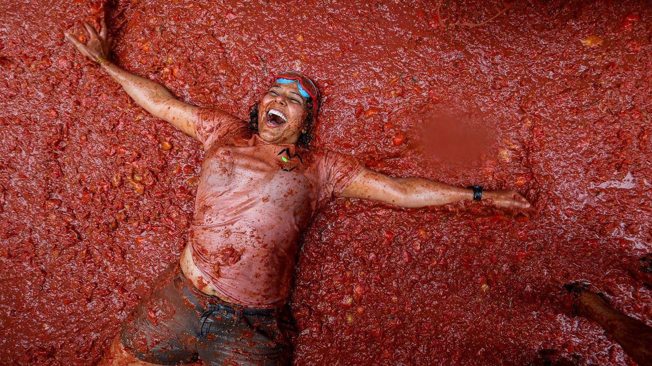 Un fêtard se repose dans une mare de tomates écrasées pendant la fête annuelle 