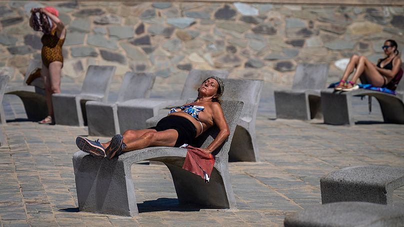 Les gens prennent le soleil sur une promenade à Barcelone, en Espagne, le 24 juillet 2024. 