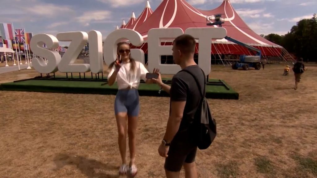 Festivalgoer takes a picture in front of Sziget sign