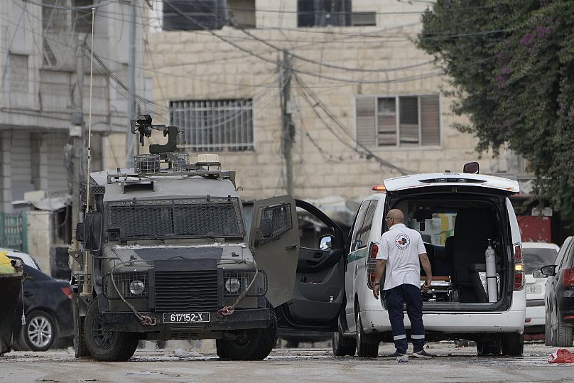 Des membres des forces israéliennes à bord d'un véhicule blindé contrôlent une ambulance lors d'une opération militaire dans la ville de Jénine en Cisjordanie.