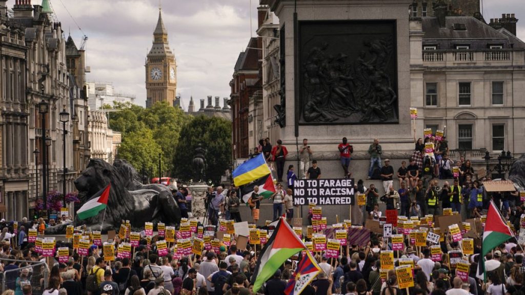 People hold placards as they march during an anti-far right protest in London, Saturday, Aug. 10, 2024.