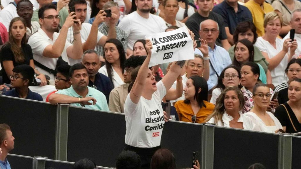 A woman holds up a placard reading