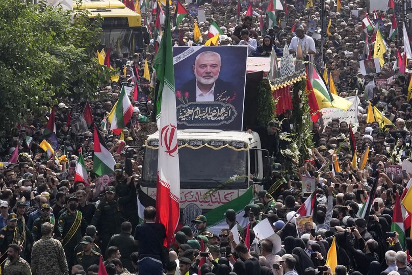 Des Iraniens suivent un camion, au centre, transportant les cercueils du chef du Hamas Ismail Haniyeh et de son garde du corps qui ont été tués dans un assassinat imputé à Israël mercredi.