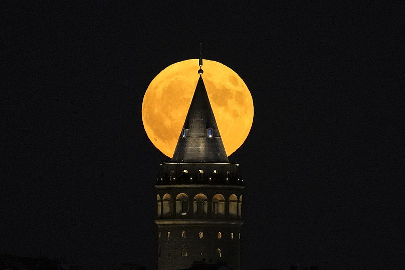 Une super lune se lève derrière la tour de Galata à Istanbul, en Turquie, le lundi 19 août 2024.