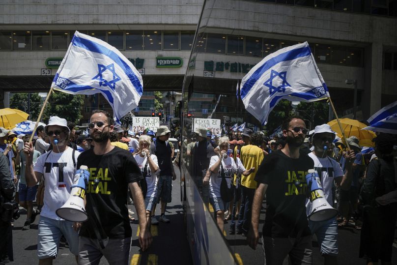 Des manifestants défilent avec des drapeaux israéliens lors d'une manifestation appelant à la libération des otages détenus dans la bande de Gaza par le Hamas, le 7 juillet 2024