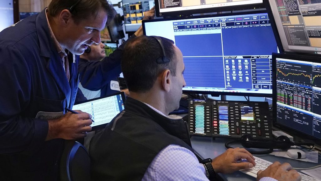 Trader Michael Milano. left, works with colleagues on the floor of the New York Stock Exchange, Wednesday, Aug. 7, 2024.