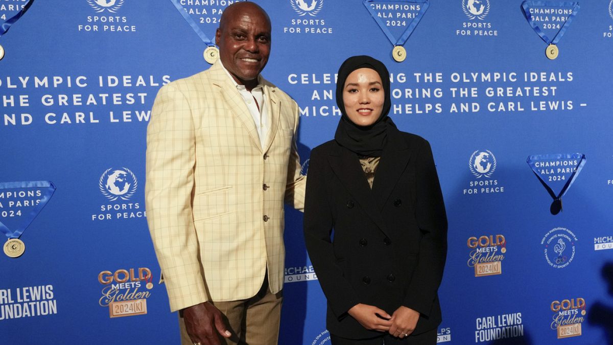 Former Olympian Carl Lewis, left, and representer of the IOC