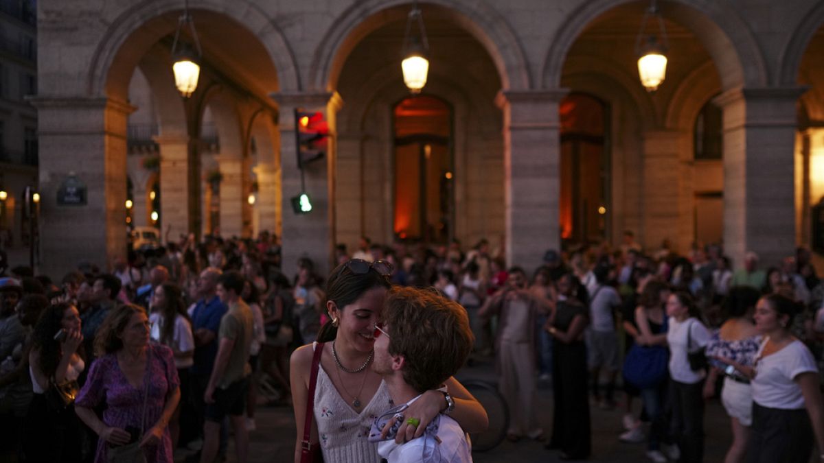 A couple embrace as they stand in the Rue de Rivoli on the final day of the 2024 Summer Olympics, Sunday, Aug. 11, 2024, in Paris, France.