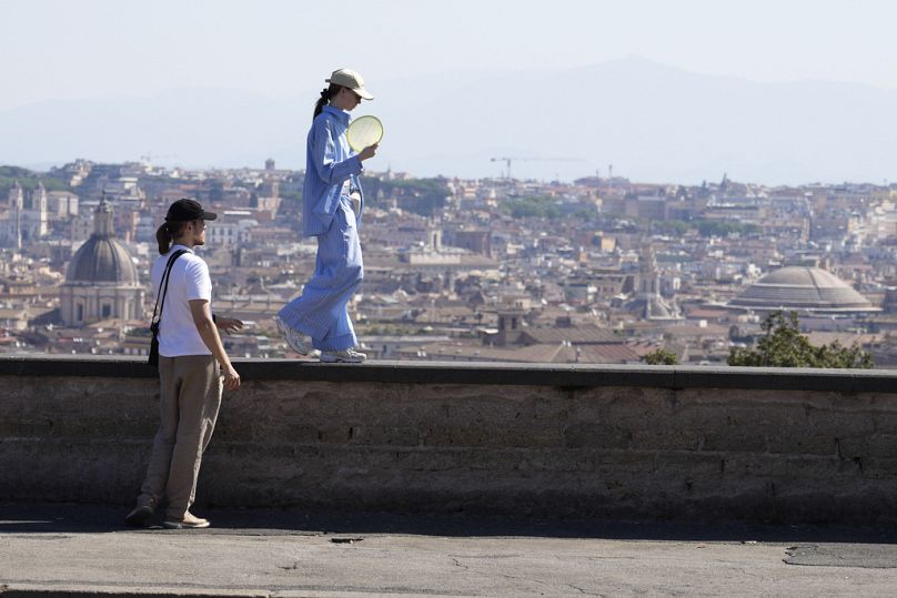 Une femme marche sur le balcon surplombant l'horizon de la ville sur la colline du Pincio à Rome. 