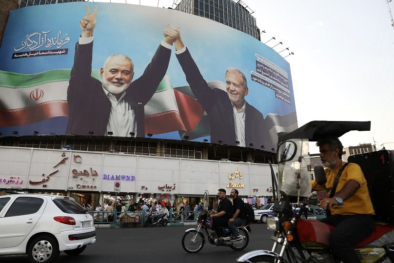 Une immense banderole montre l'ancien chef du Hamas Ismail Haniyeh, tenant la main du président iranien Masoud Pezeshkian à Téhéran.