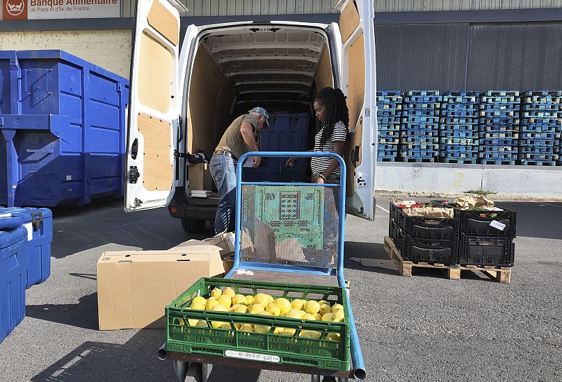 Manuel Pintos, bénévole du Maillon, charge des marchandises dans un véhicule pour la distribution de nourriture, le mardi 6 août 2024, lors des Jeux olympiques d'été de 2024, à Gennevilliers, en France. 