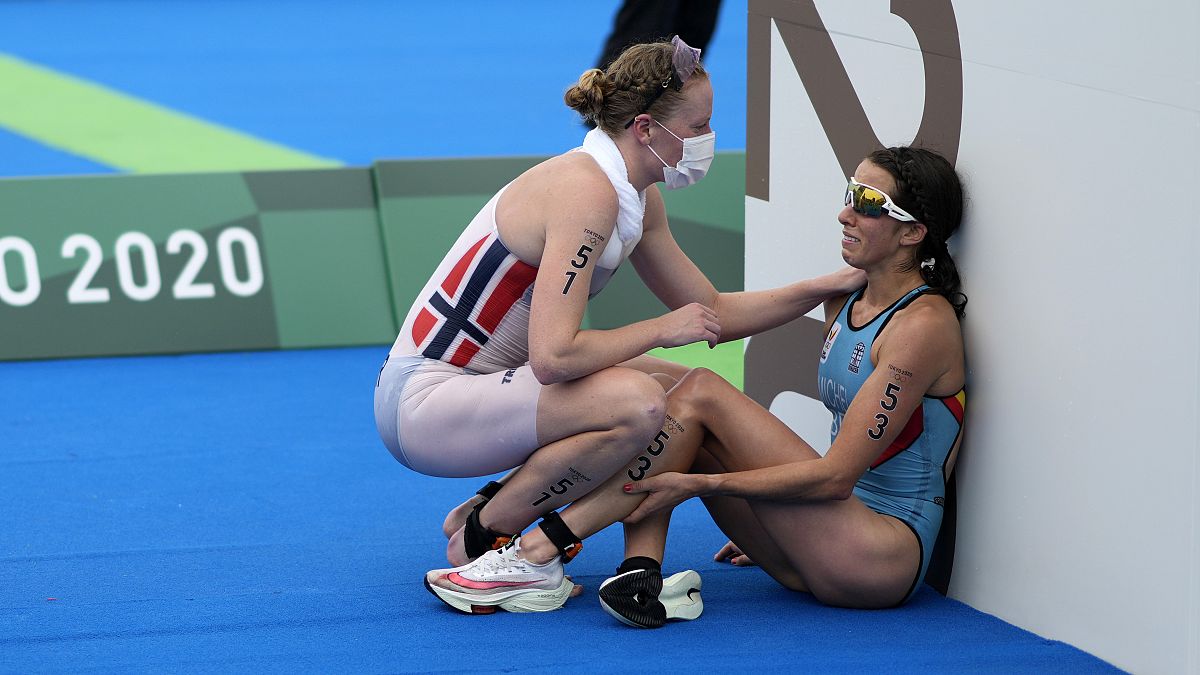 Claire Michel, of Belgium, is assisted by Lotte Miller of Norway after the finish of the women