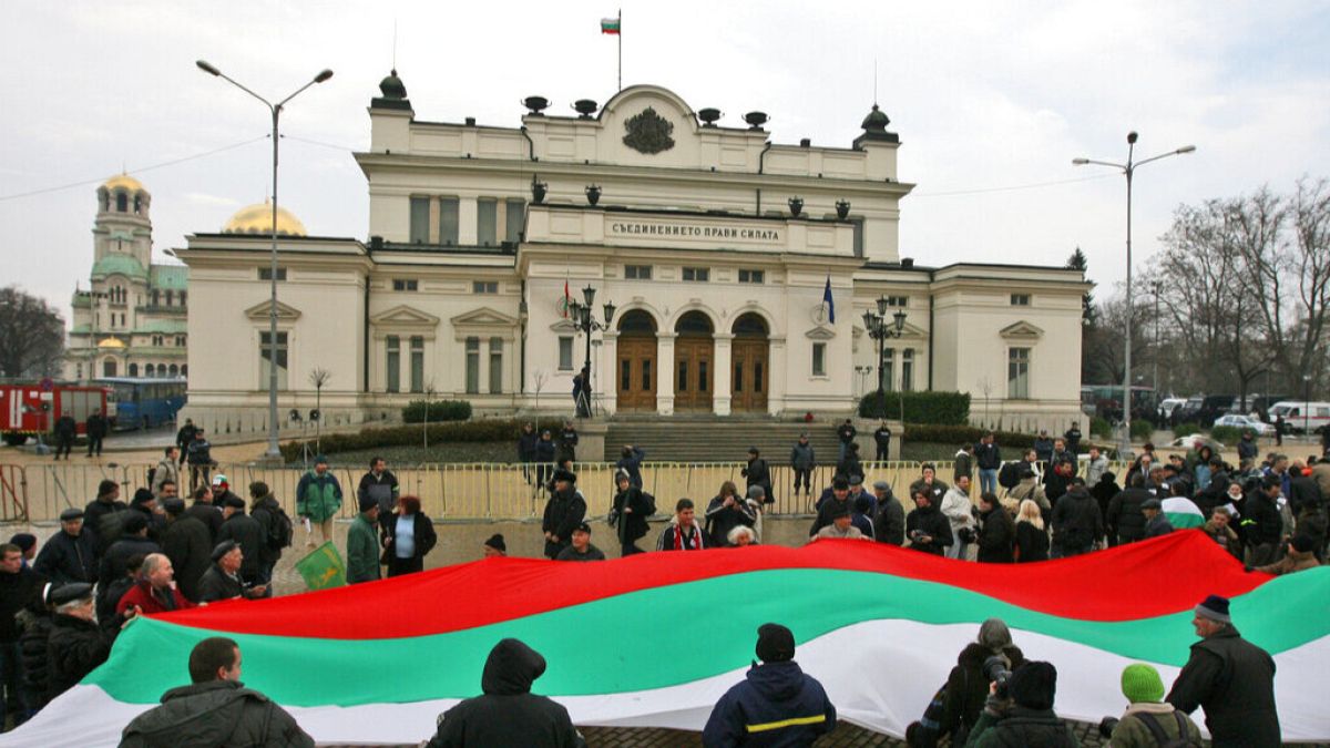 Protesters hold a large Bulgarian national flag and shout slogans during an anti government protest in front of the Bulgarian parliament building in the capital Sofia, 2009.