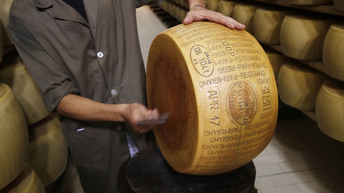 Quality control employee inspects a Parmigiano Reggiano Parmesan cheese in Noceto, Parma, Italy, Tuesday, Oct. 8, 2019.