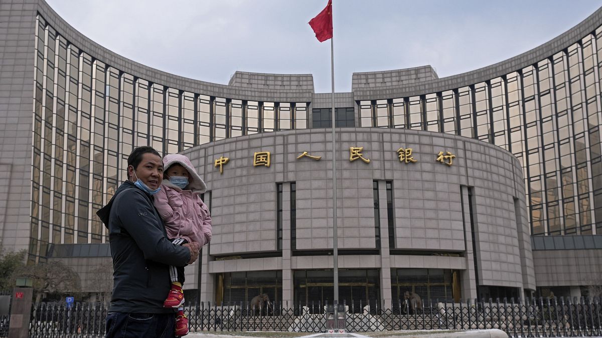 A man carries a child in front of China